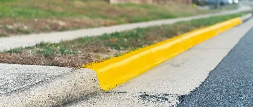Yellow curb and fire lane striping in a residential community, showing fresh traffic paint