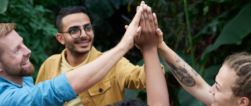 a group of people giving each other a high five, persone che si supportano dandosi una mano