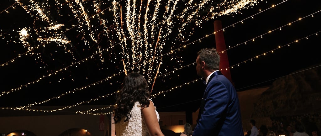 Golden fireworks bursting as the couple makes their unforgettable wedding entrance.