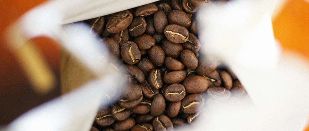 close-up shot of freshly roasted to order coffee beans in a coffee bag