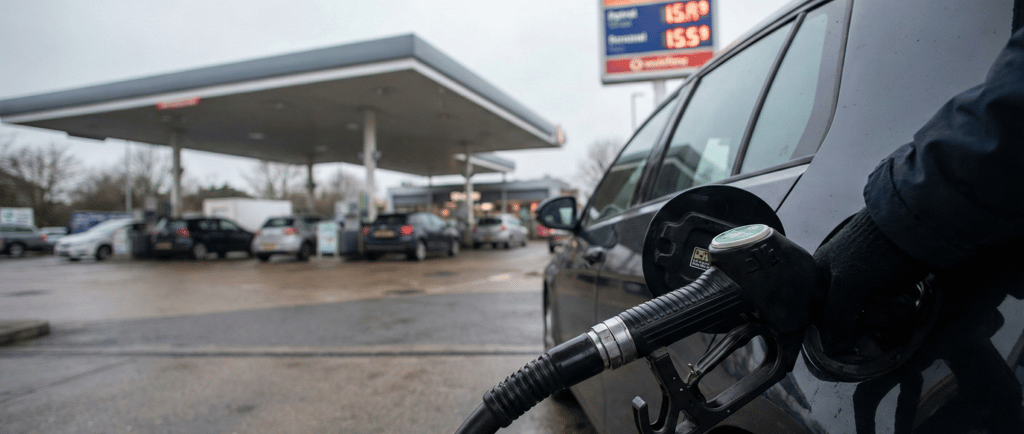 A driver fuelling their vehicle at a UK petrol station forecourt, illustrating rising fuel costs