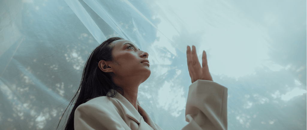 a woman in a white robe is holding her hands up to the sky