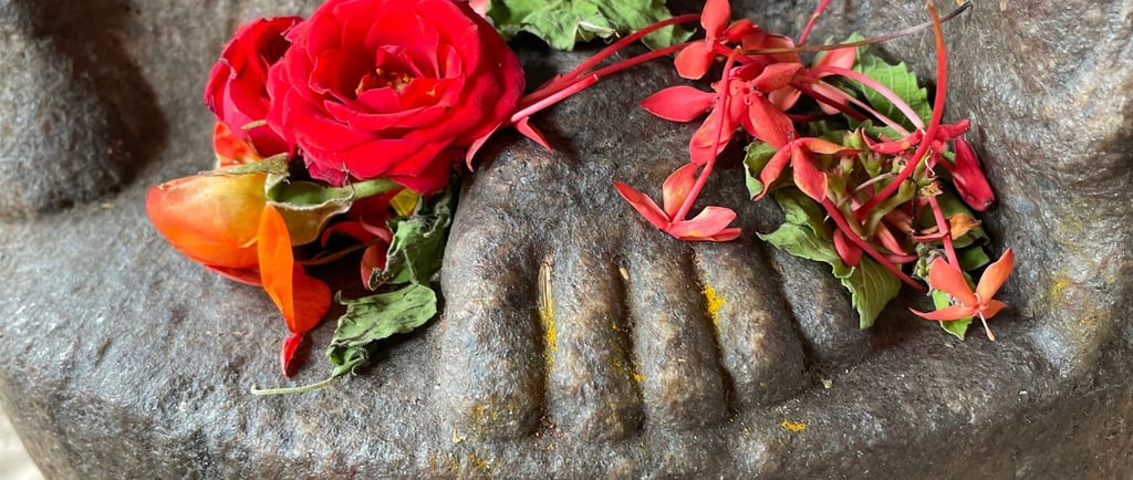 The feet of a statue covered in flowers
