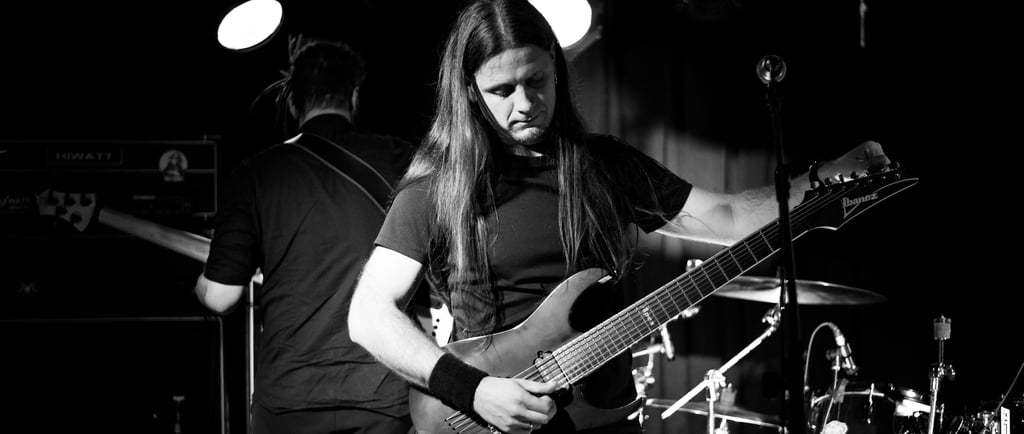 a man tuning guitar on stage