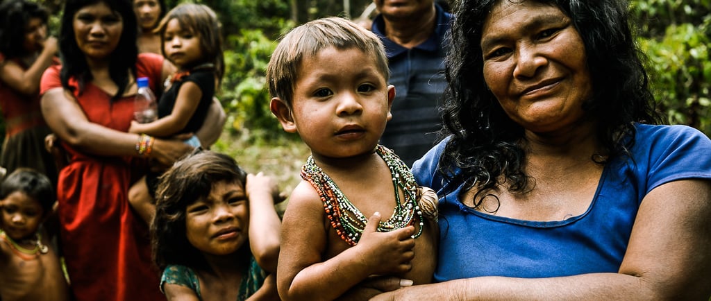 une femme piraha qui tient un enfant dans ses bras