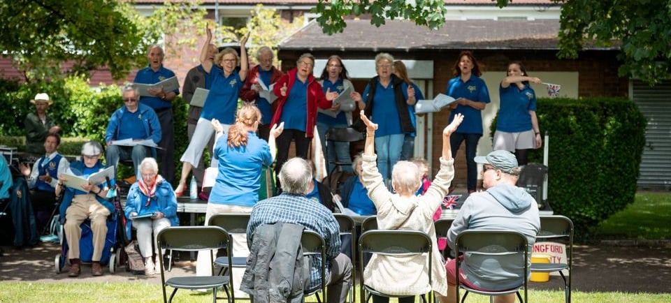 Choir singing on stage in park