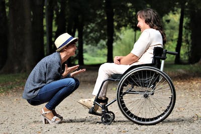 a woman in a wheelchair is talking to a man in a wheelchair