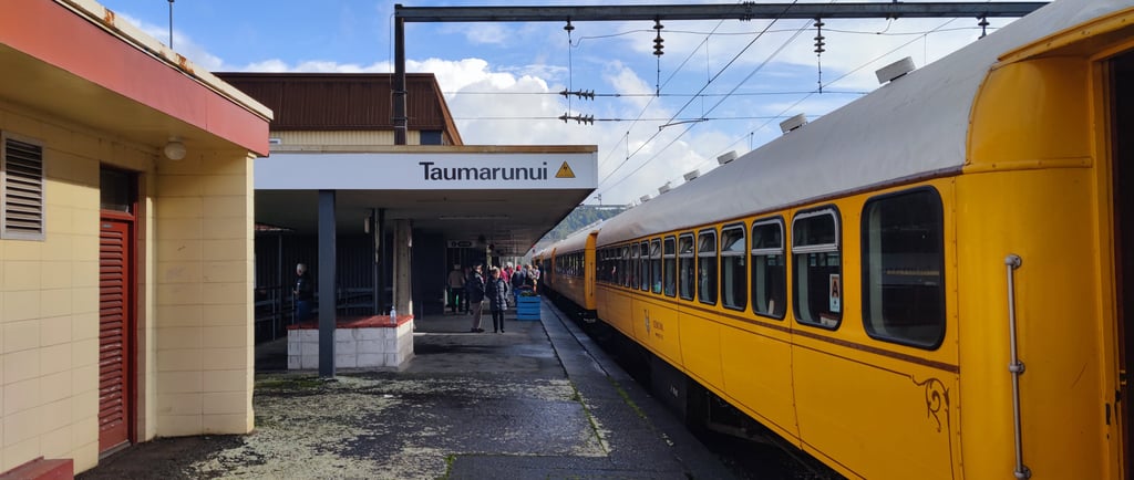 a yellow train is parked at Taumarunui train station