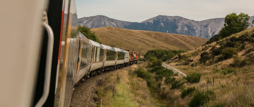 a train traveling down a mountain side by side