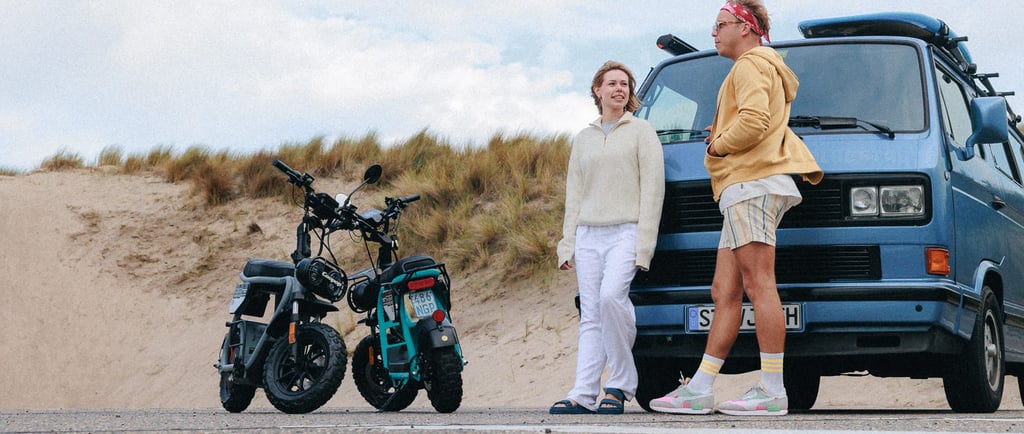 a man and woman standing next to a parked motorcycle