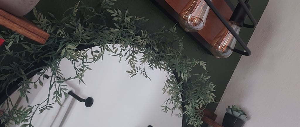 a bathroom with a mirror and a plant in the middle
