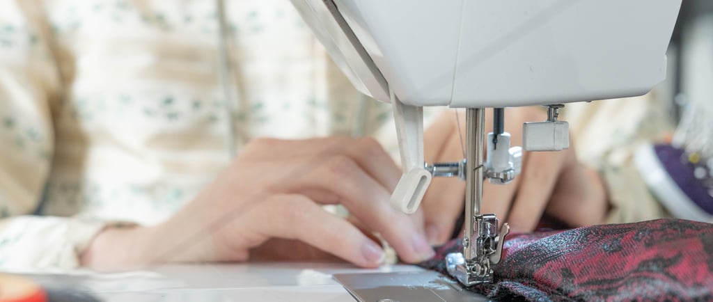 Mains guidant le tissu sur une machine à coudre