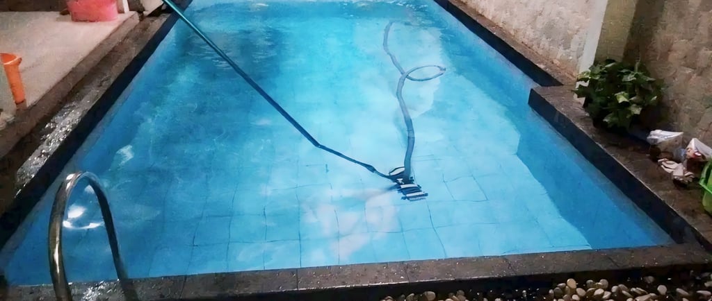 Proses mengvacum kolam renang.