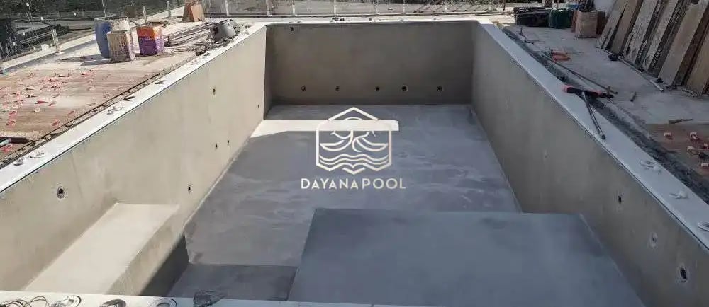 Kolam renang beton dengan finishing batu alam hijau.