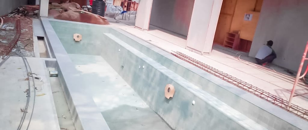 Kolam renang beton dengan finishing batu alam hijau.