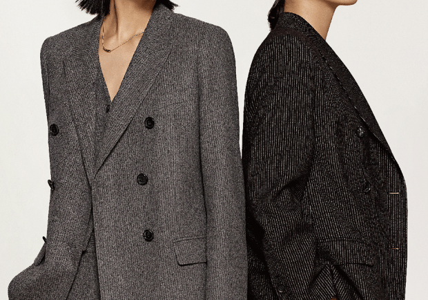 two women in suits standing next to each other