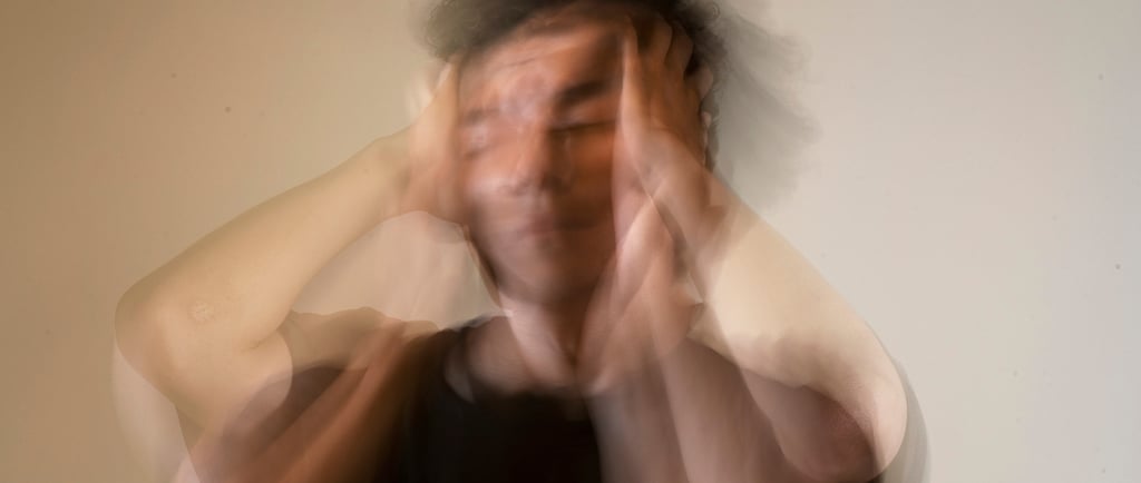 Размытое изображение человека, держащегося руками за голову. Эффект движения