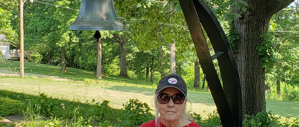 Lady in front of school bell