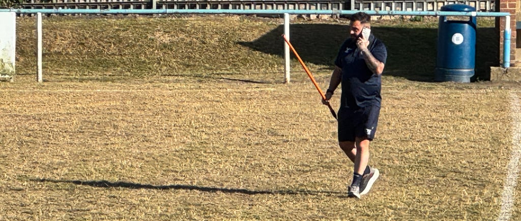 Referee checking the playing urface of a rugby field.