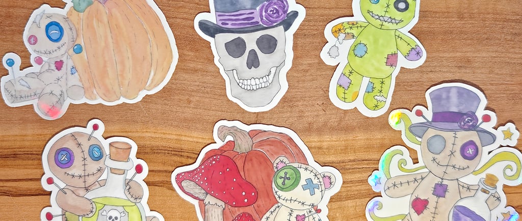 Watercolor voodoo doll and skull stickers against a wood background.