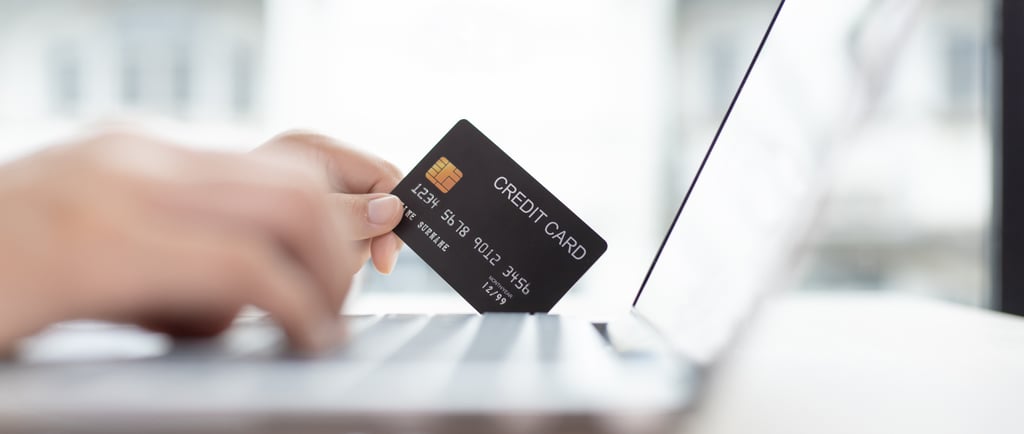 Person using a credit card while online shopping with a Laptop computer