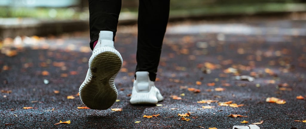 a person walking on a path with leaves