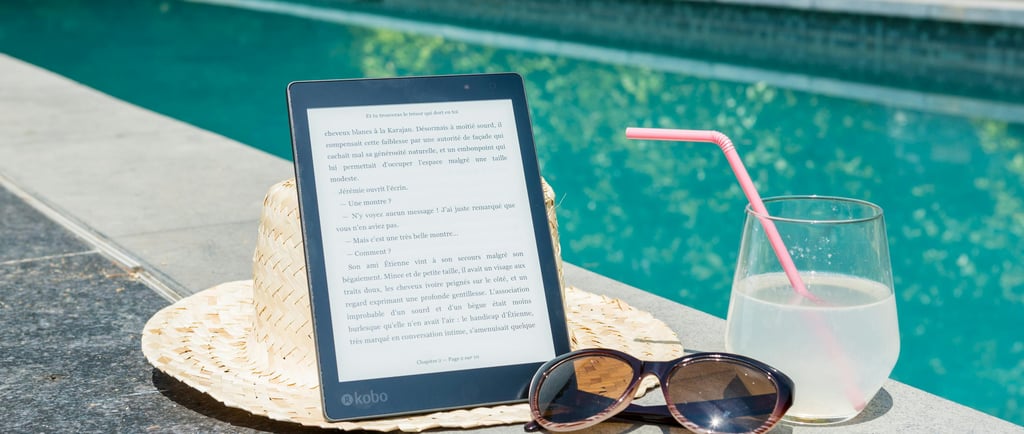 a tablet with a straw hat and sunglasses next to a pool