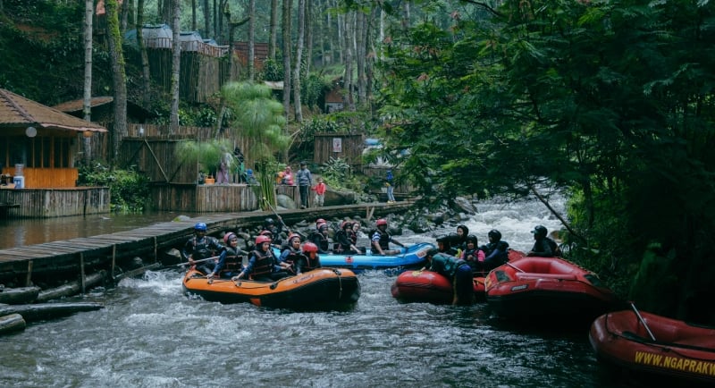 Rafting Pangalengan di Sungai Palayangan: Peserta siap berarung jeram di sungai dengan latar belakang hutan pinus yang rindan