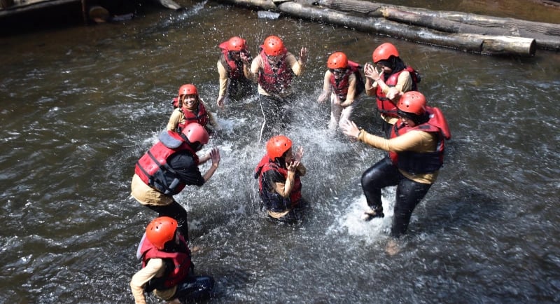 Pemandangan atas sekelompok peserta Fluir Adventure sedang bersenang-senang dan bermain air di sungai setelah arung jeram di 