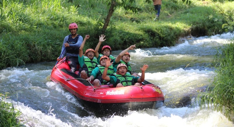 Peserta menikmati keseruan Pangalengan rafting di Sungai Palayangan dengan perahu karet merah bersama Fluir Adventure.