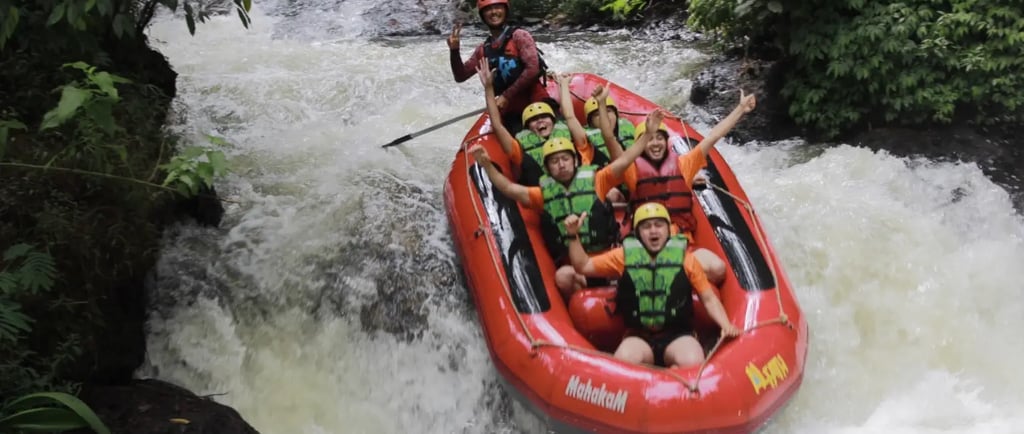 Kelompok peserta rafting menuruni jeram di Sungai Palayangan, Situ Cileunca, dengan perahu karet merah