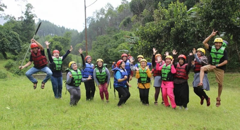 Foto ceria wisatawan saat rafting di Pangalengan, dengan jaket pelampung dan ban karet, menunjukkan keseruan wisata Pangaleng
