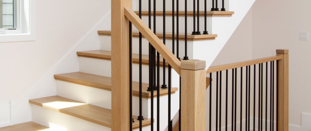 Modern wood stairs with solid oak rails and black iron balusters