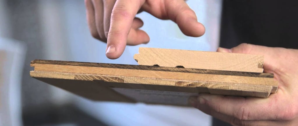 Professional guiding and showing the difference between solid and engineered hardwood boards.
