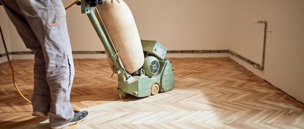 Pro sanding wood floors with a belt sander.