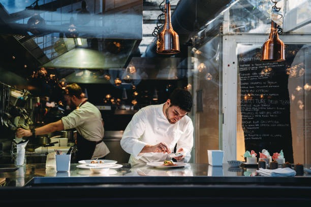 Dos chefs preparando comida en la cocina