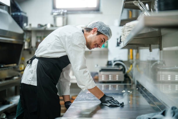 Chef sonriente limpiando la encimera de la cocina