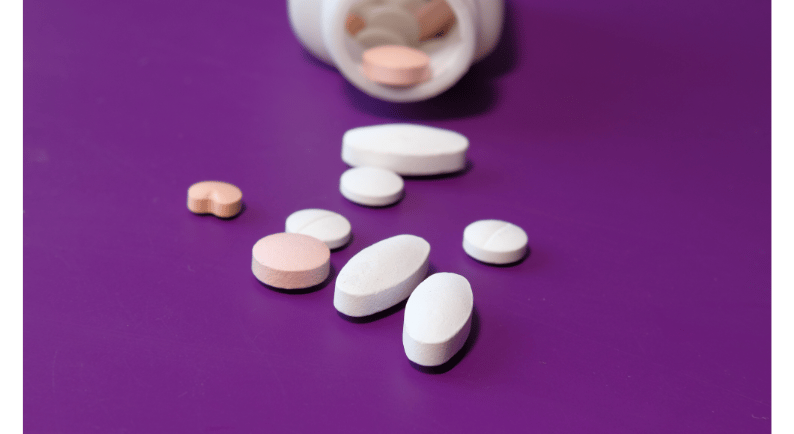 a bottle of medicine pills and pills on a purple background