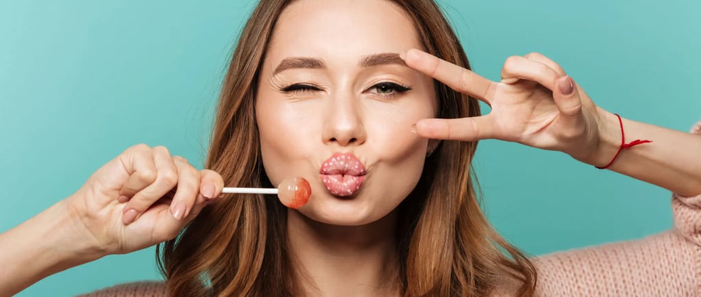 a woman with a pink lippy and a lollipop in her mouth