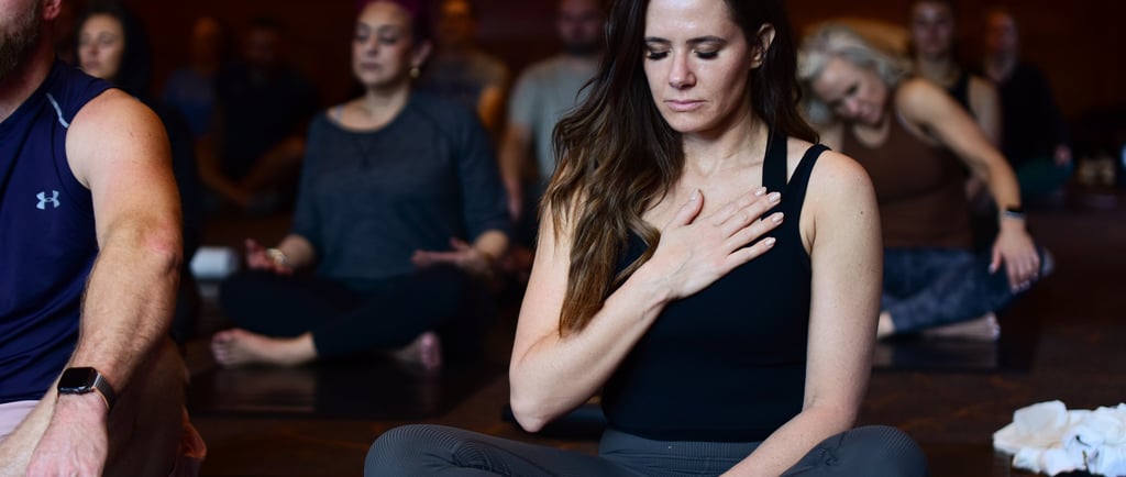 a woman sitting on a yoga mat in a yoga class retreat event planner