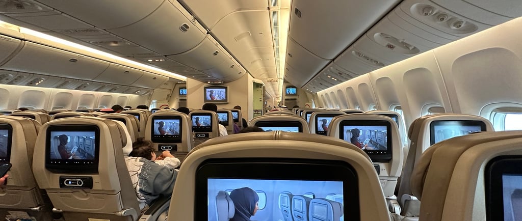 a group of people sitting in a saudi airline plane