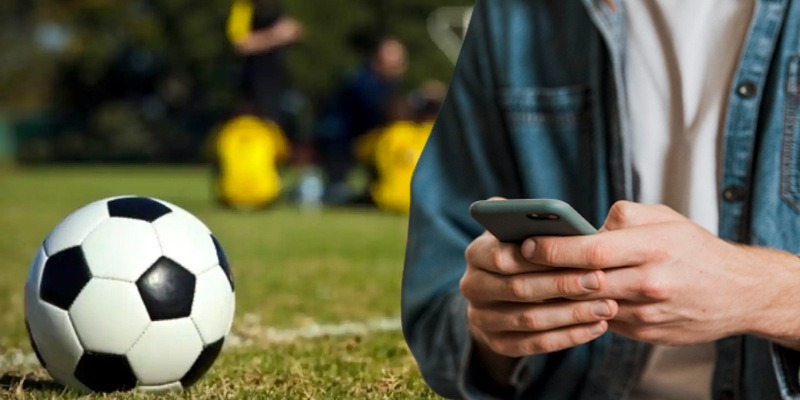 a man in a blue shirt is holding a cell phone