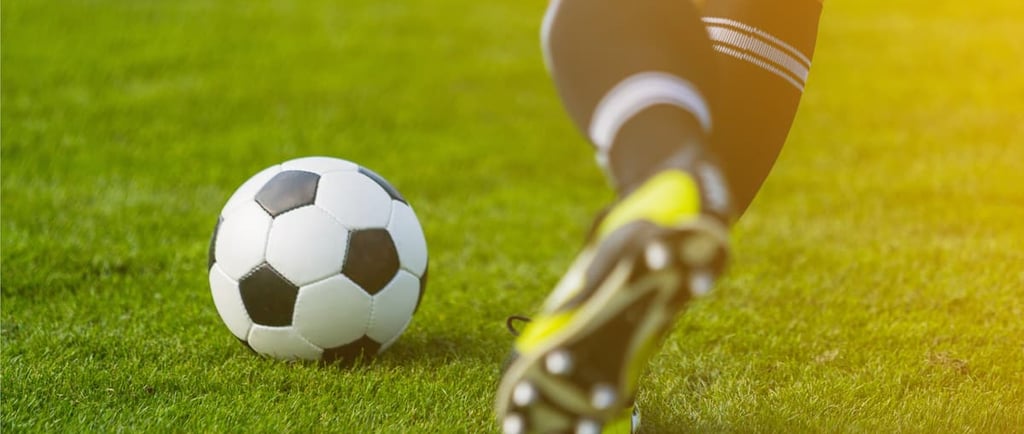  Un jugador de fútbol pateando un balón de fútbol en un campo