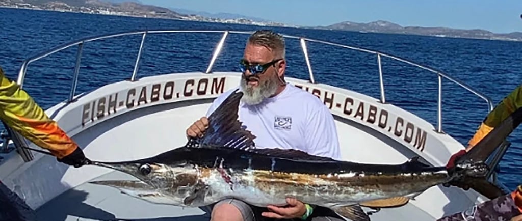 a man holding a fish on a boat