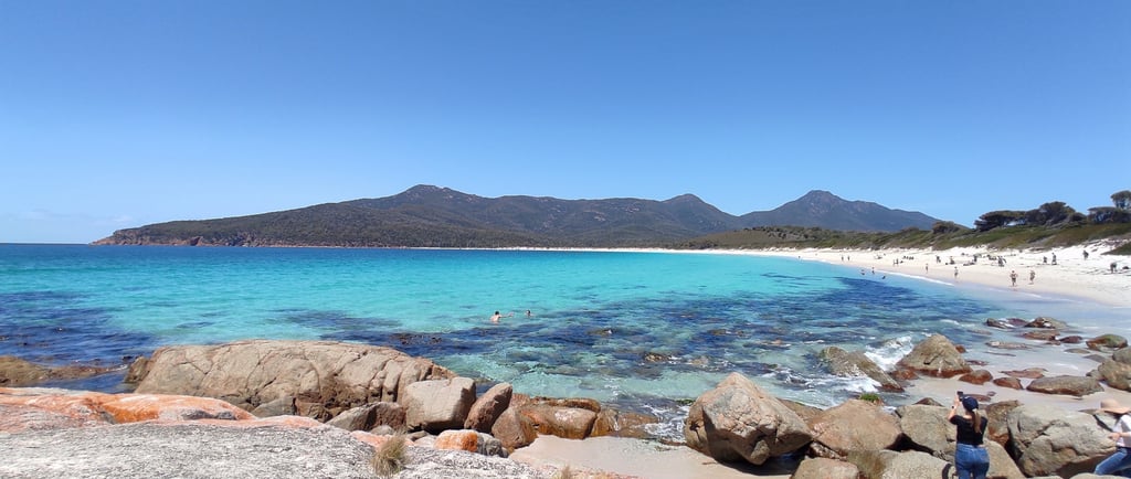 Freycinet bay sandy beach with rocks and mountain view