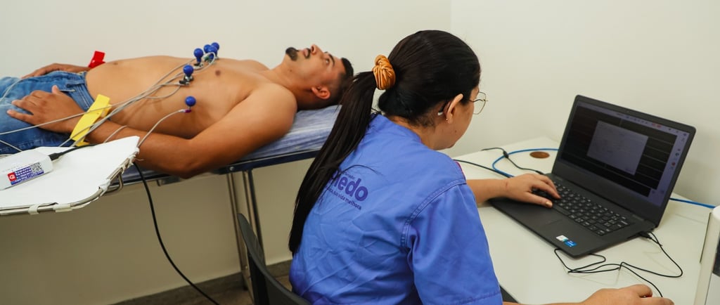 mulher em um computador e um homem em uma maca fazendo exames