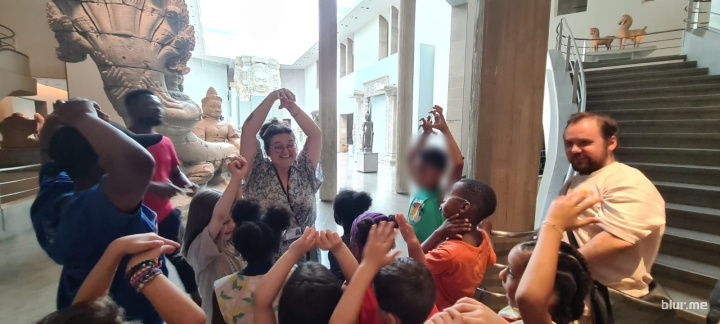 Des enfants tendent les bras vers le haut au musée Guimet