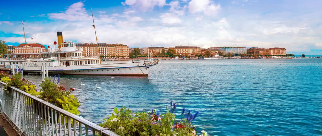 an image of a lake with nice water, houses and boats
