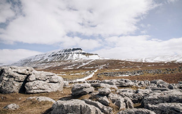 Distant view of Pen-y-ghent peak with snow covering the summit in the Yorkshire Dales, England