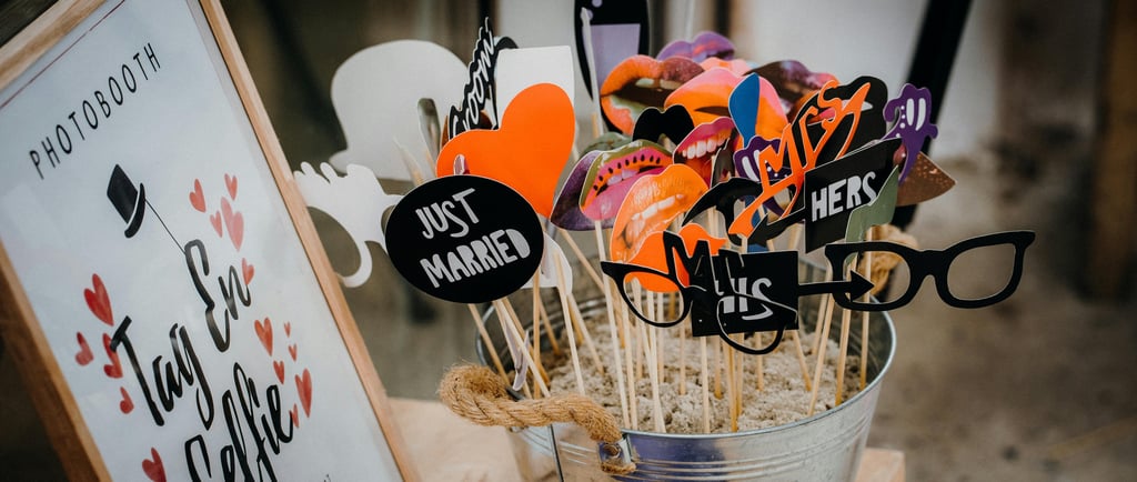 des accessoires de photobooth dans un pot pour les invités et une pancarte invitant à prendre un sel